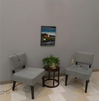 Two grey chairs and a side table in the station lounge